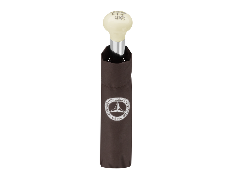 300 SL gear knob compact umbrella. Brown. Chromed steel shaft. 100% polyester canopy with special water- and dirt-repellent coating. Fibreglass/metal ribs. Manual opening. “Windproof” design. Handle designed to resemble 300 SL gear knob. Diameter when open approx. 97 cm. Length approx. 30 cm (closed)<font face="CorpoS"><span style="font-size: 14.6667px;"><em>.</em></span></font>